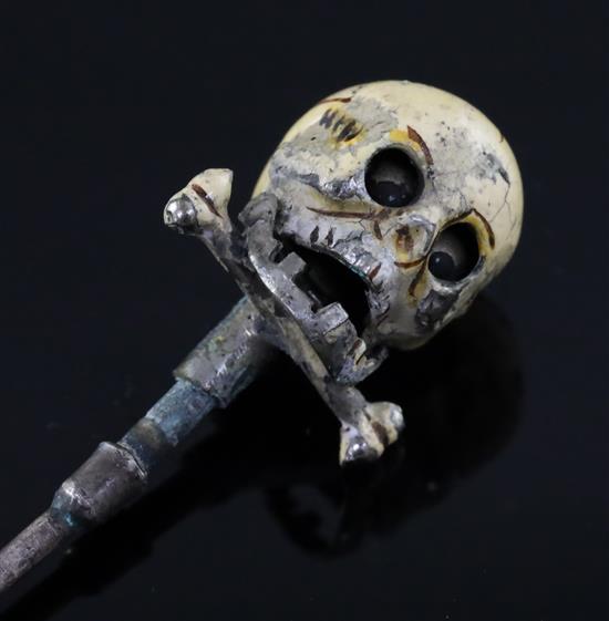 A 19th century French? base metal and cream enamel skull head stick pin, in the manner of Trouve & Cadet-Picard, overall 73mm.